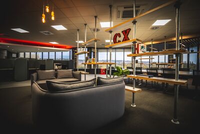 Looking through the office with sofas, scaffolding shelves and large 