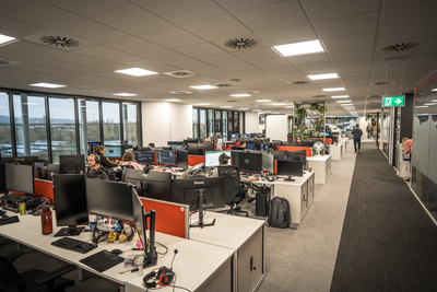 Walking down cprridor in an office besides rows of desks